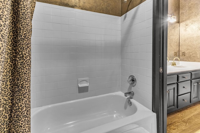 bathroom featuring hardwood / wood-style floors, vanity, and tiled shower / bath combo