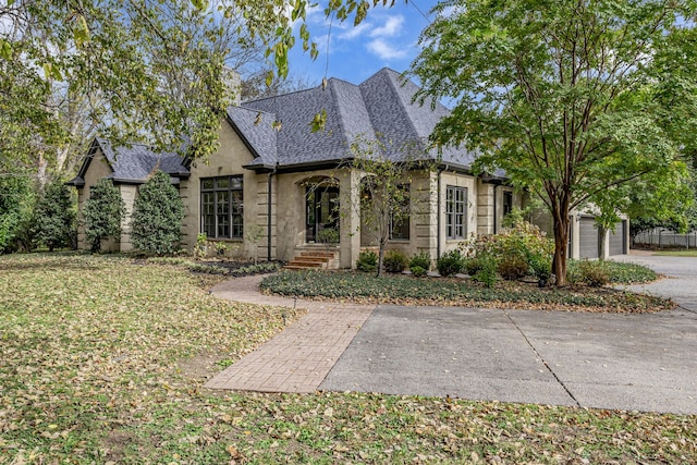 french provincial home featuring a front lawn and a garage