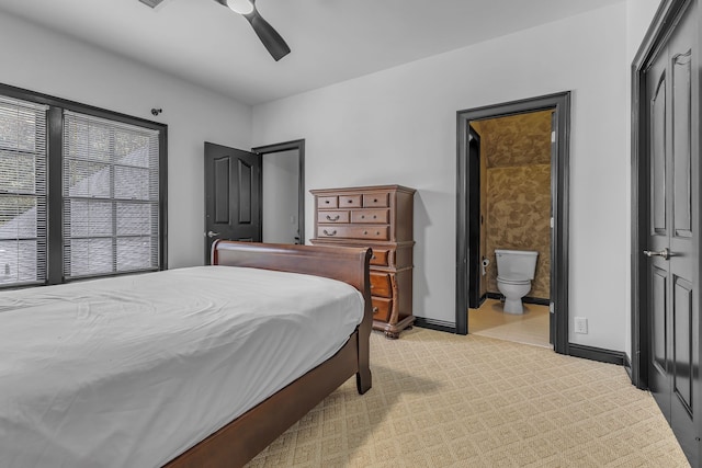 carpeted bedroom featuring a closet, ceiling fan, and ensuite bath