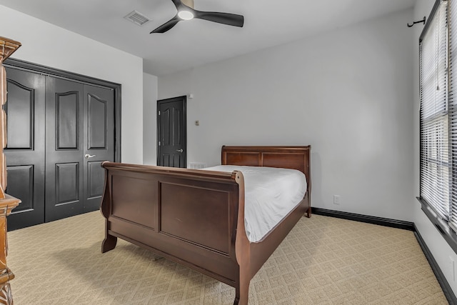 bedroom with light carpet, ceiling fan, and a closet