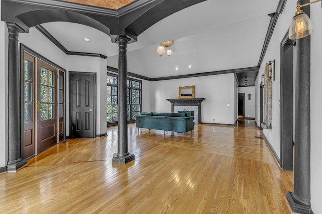 entryway with ornamental molding, hardwood / wood-style floors, a fireplace, and decorative columns