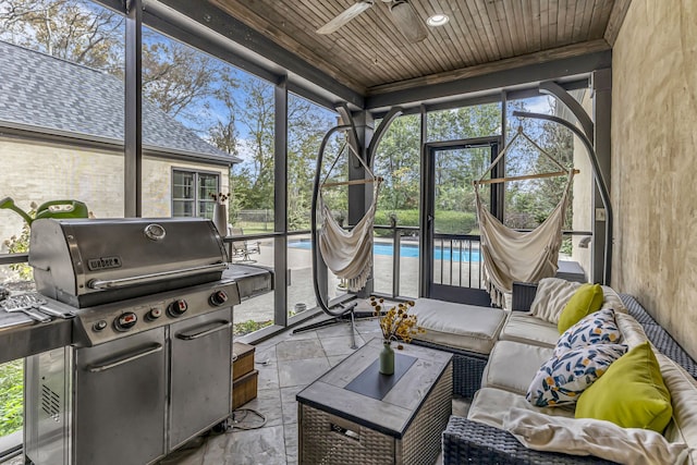 sunroom featuring ceiling fan and wooden ceiling