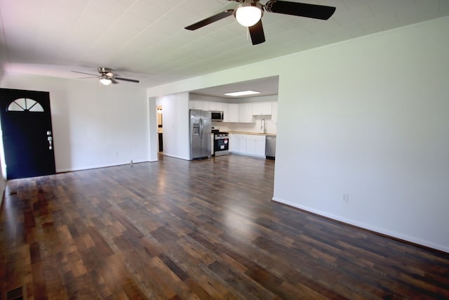 unfurnished living room featuring ceiling fan and dark hardwood / wood-style flooring