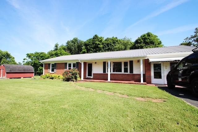 ranch-style home featuring covered porch and a front lawn