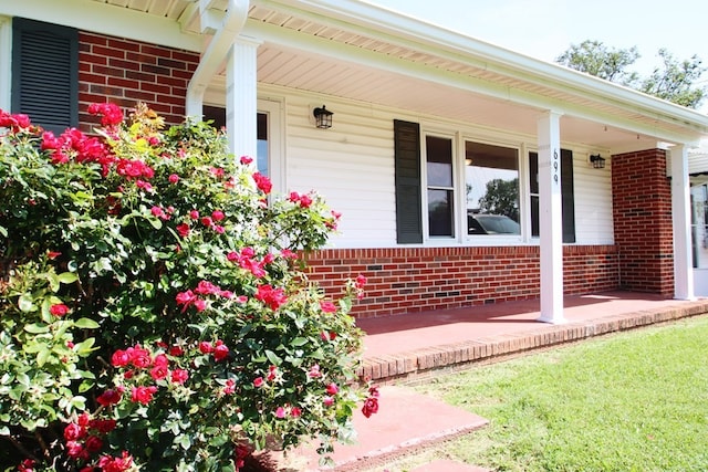 doorway to property featuring a yard and a porch