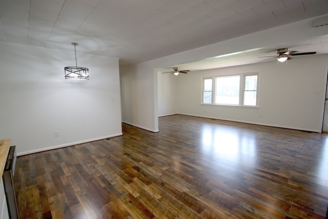 interior space with dark wood-type flooring and ceiling fan with notable chandelier