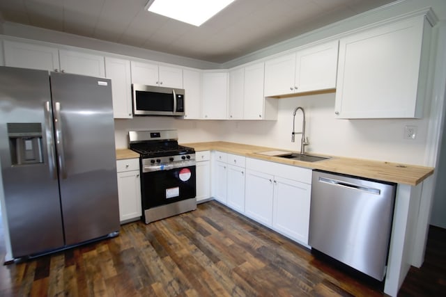 kitchen featuring white cabinetry, sink, appliances with stainless steel finishes, butcher block countertops, and dark hardwood / wood-style flooring