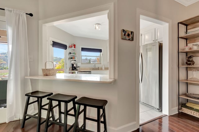 kitchen featuring sink, hardwood / wood-style flooring, a kitchen breakfast bar, and stainless steel appliances