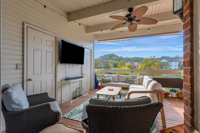 sunroom / solarium featuring beamed ceiling and ceiling fan