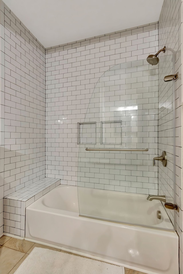 bathroom with bath / shower combo with glass door and tile patterned floors