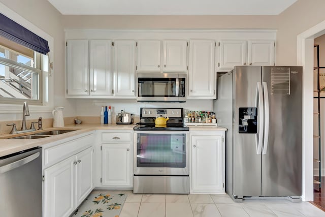 kitchen featuring white cabinetry, stainless steel appliances, and sink