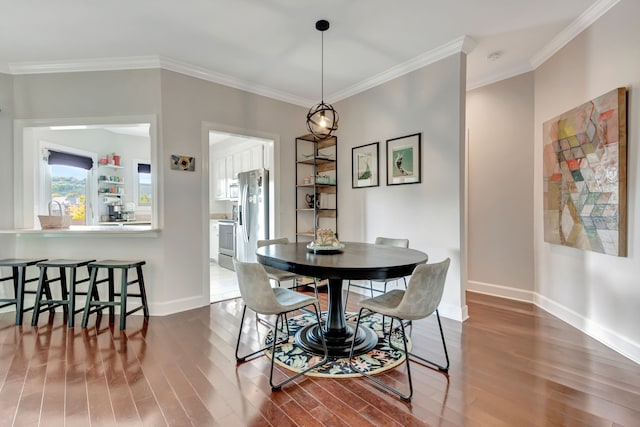 dining space featuring dark hardwood / wood-style floors and ornamental molding