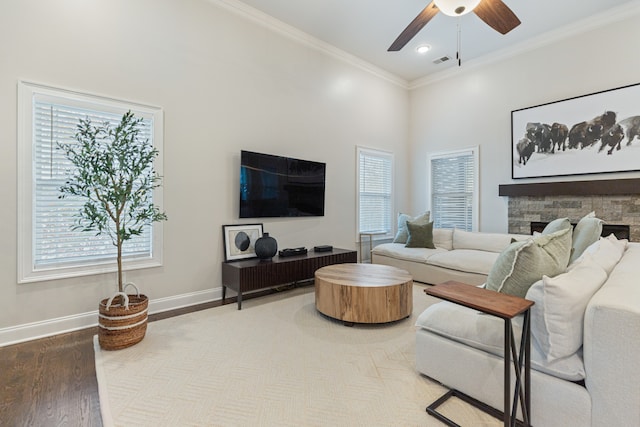 living room with wood-type flooring, a healthy amount of sunlight, and ornamental molding