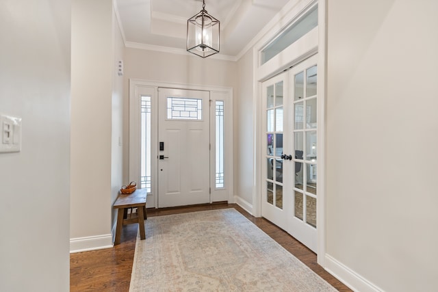 entryway featuring dark wood-type flooring, french doors, crown molding, and a tray ceiling