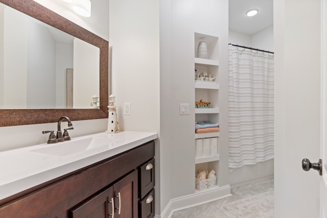 bathroom featuring a shower with curtain, vanity, tile patterned floors, and built in shelves