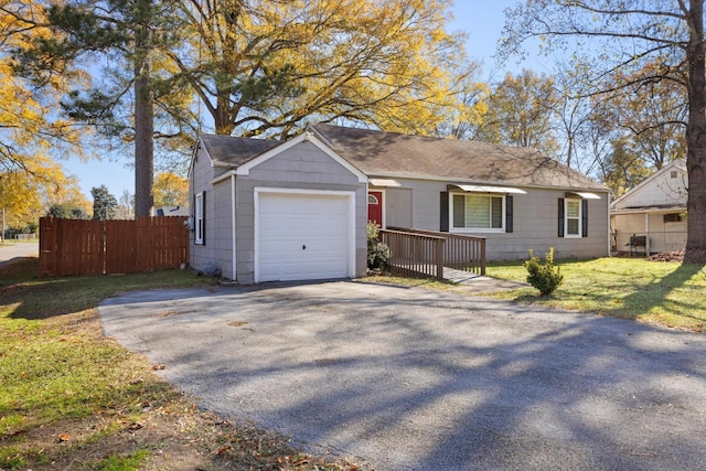 single story home featuring a garage and a front lawn