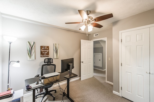 home office featuring a textured ceiling, ceiling fan, and carpet floors