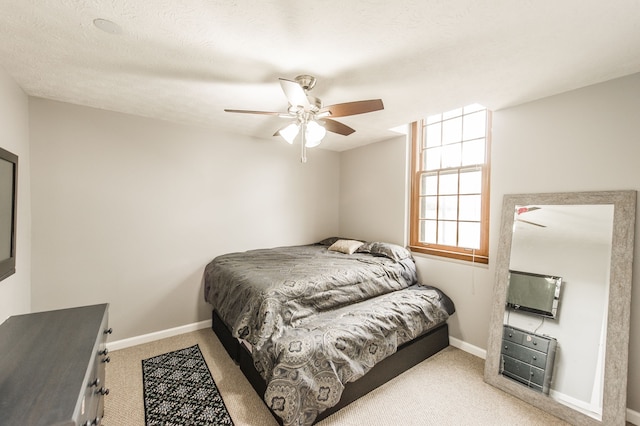 carpeted bedroom with ceiling fan and a textured ceiling