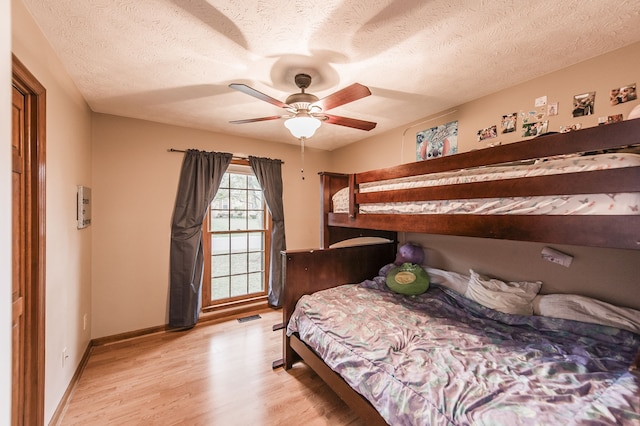 bedroom featuring ceiling fan, a textured ceiling, and light hardwood / wood-style flooring