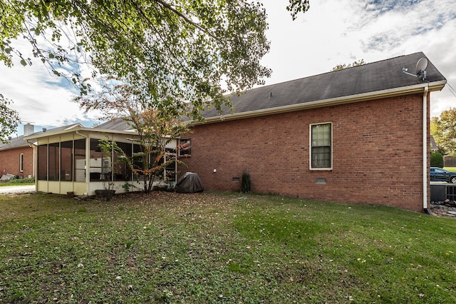 view of property exterior featuring a sunroom and a lawn