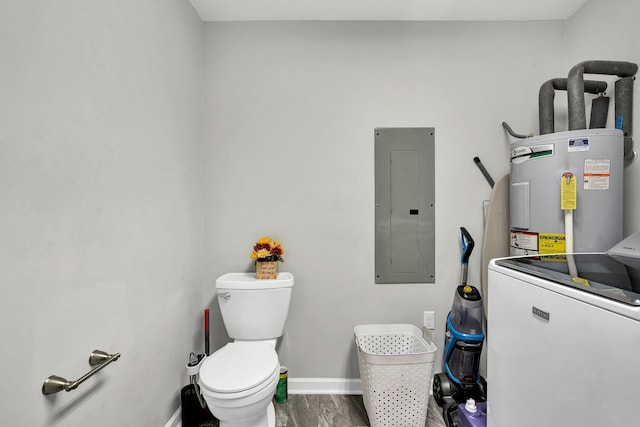 bathroom featuring electric water heater, electric panel, toilet, wood-type flooring, and washer / clothes dryer