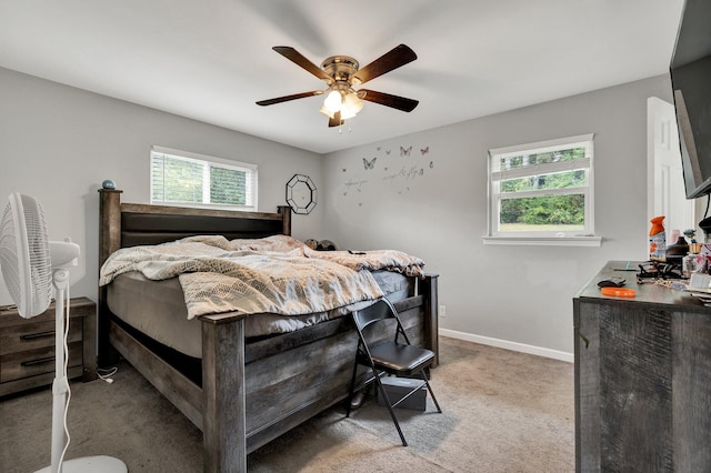 carpeted bedroom featuring multiple windows and ceiling fan