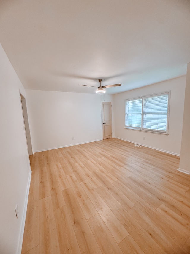 spare room with ceiling fan and light wood-type flooring