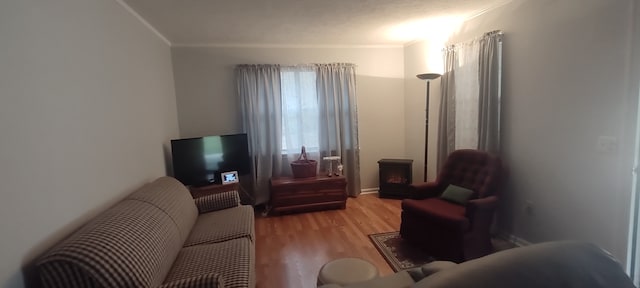 living room with light wood-type flooring and ornamental molding