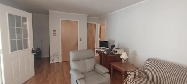 living area featuring hardwood / wood-style flooring and crown molding