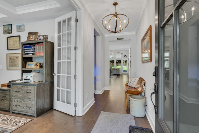 foyer entrance featuring dark wood-type flooring, a chandelier, and ornamental molding