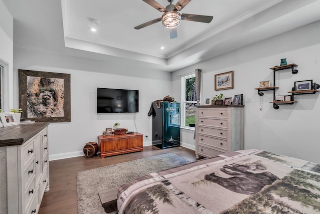 bedroom with crown molding, dark wood-type flooring, ceiling fan, and a raised ceiling