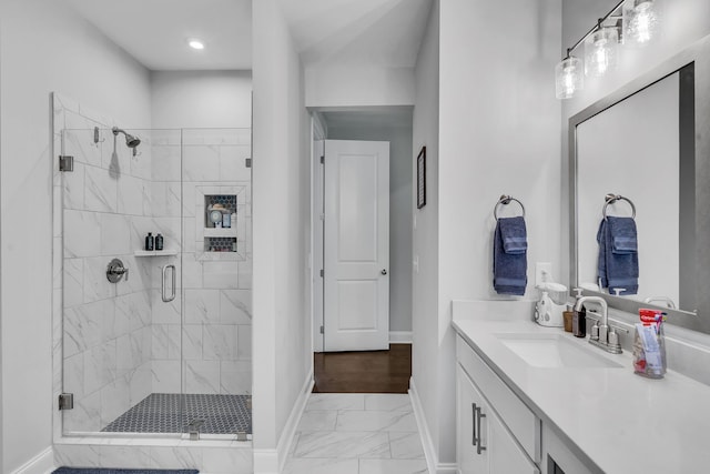 bathroom with an enclosed shower, vanity, and wood-type flooring