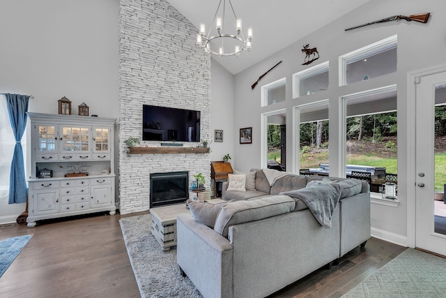 living room with high vaulted ceiling, dark hardwood / wood-style flooring, a chandelier, and a fireplace