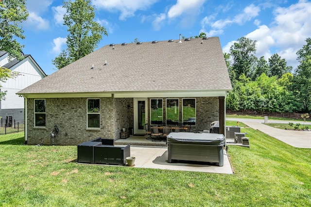 rear view of house with a patio, a yard, a hot tub, and an outdoor hangout area