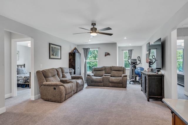 carpeted living room with ceiling fan