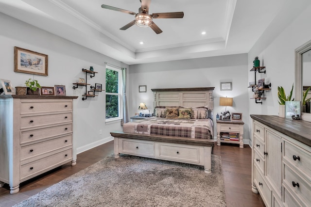 bedroom with dark wood-type flooring, ceiling fan, ornamental molding, and a tray ceiling