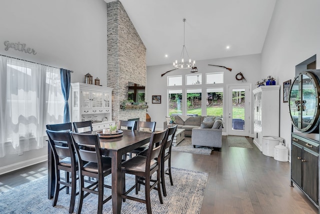 dining area featuring high vaulted ceiling, an inviting chandelier, dark hardwood / wood-style floors, and a fireplace