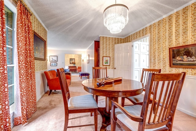 dining space with light carpet, wallpapered walls, ornamental molding, and a textured ceiling