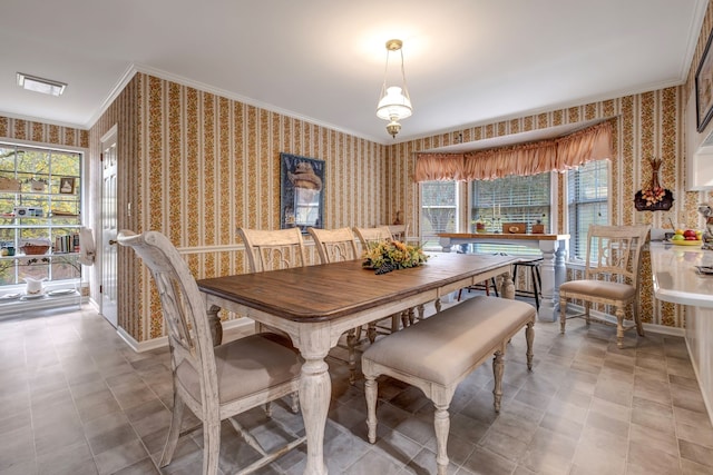 dining space featuring crown molding, baseboards, and wallpapered walls