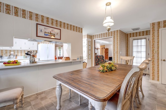 dining room with crown molding, visible vents, and wallpapered walls