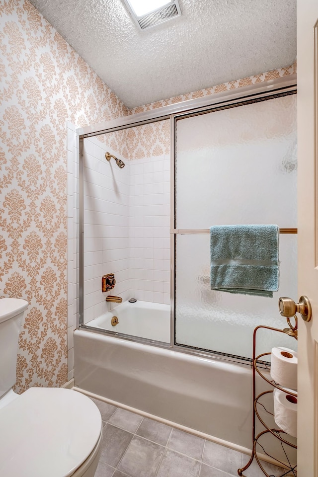 bathroom featuring tile patterned floors, a textured ceiling, toilet, and wallpapered walls