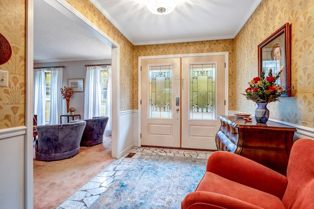 entryway featuring a wainscoted wall, carpet floors, crown molding, and wallpapered walls