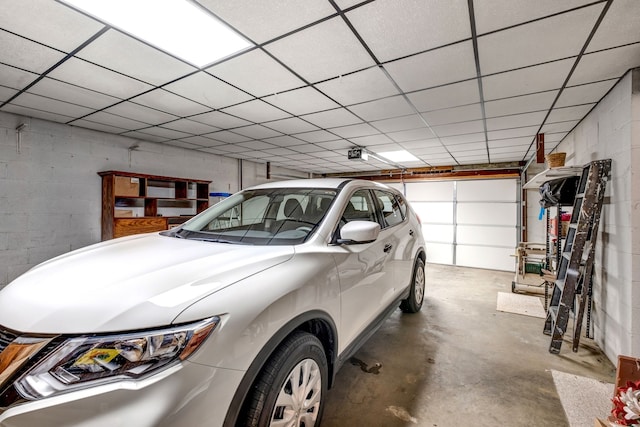 garage featuring a garage door opener and concrete block wall