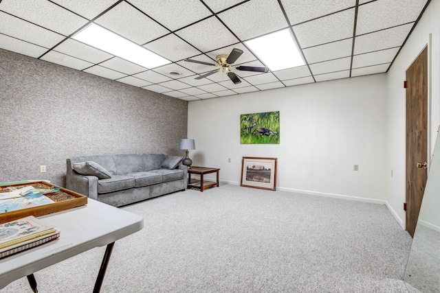 living room with carpet, a paneled ceiling, and baseboards