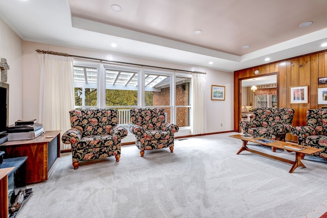 living area with recessed lighting, a raised ceiling, visible vents, light carpet, and wood walls