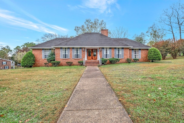 single story home featuring a shingled roof, brick siding, a chimney, and a front lawn