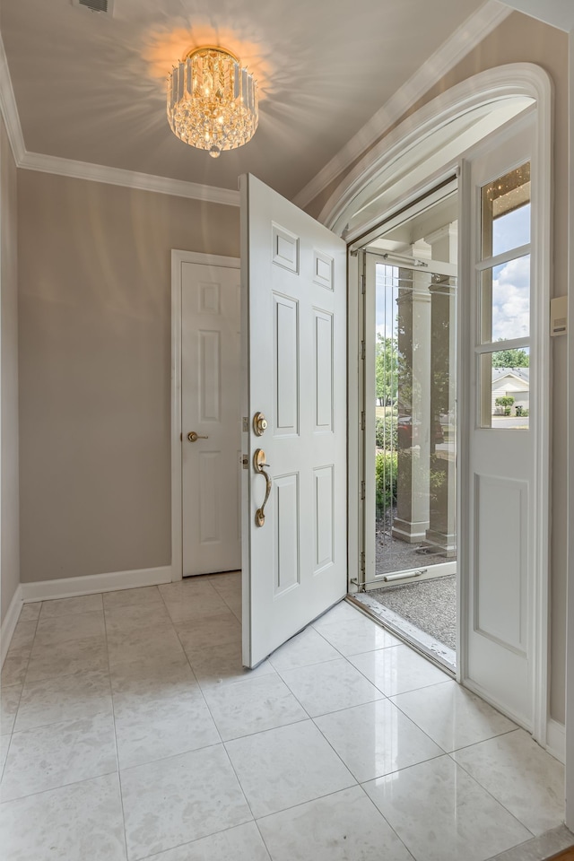 entryway with a notable chandelier, light tile patterned floors, and crown molding