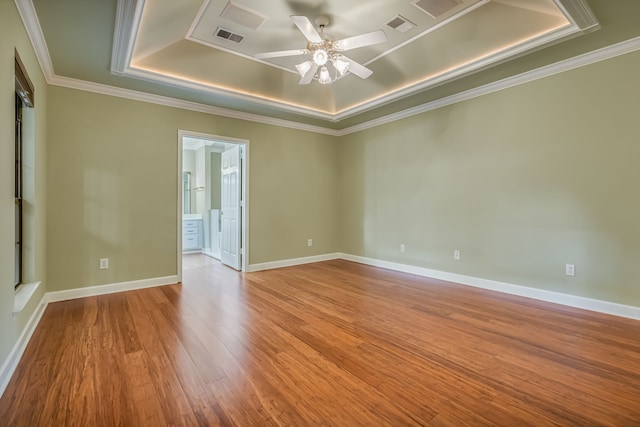 unfurnished room featuring crown molding, light hardwood / wood-style flooring, ceiling fan, and a raised ceiling