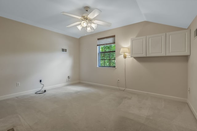 empty room with light colored carpet, lofted ceiling, and ceiling fan