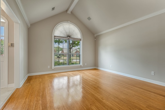 empty room with ornamental molding, vaulted ceiling with beams, and light hardwood / wood-style floors